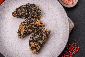 Delicious fresh crispy chicken or fish nuggets on a dark concrete background photo