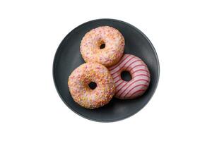 Delicious sweet bright donuts with cream on a plain background photo