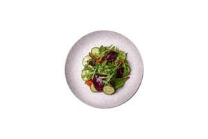 Delicious fresh salad with arugula, spinach, cucumber and cherry tomatoes in a ceramic plate photo