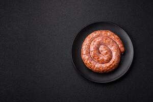 Delicious grilled sausage in the form of a ring with salt, spices and herbs photo