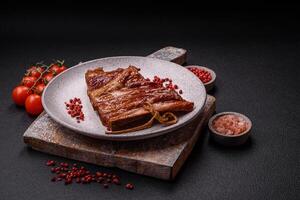 Delicious smoked or grilled ribs with olives, spices and herbs photo