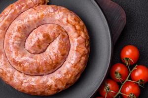 Delicious grilled sausage in the form of a ring with salt, spices and herbs photo