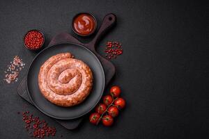 Delicious grilled sausage in the form of a ring with salt, spices and herbs photo