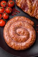Delicious grilled sausage in the form of a ring with salt, spices and herbs photo