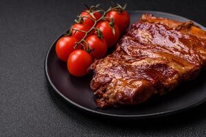 Delicious smoked or grilled ribs with olives, spices and herbs photo
