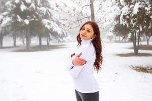 bonito niña en invierno bosque, joven mujer en invierno parque foto