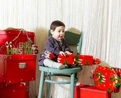 the little child playing with christmas decorations in studio, little child with christmas ball photo