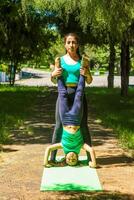joven madre y hija haciendo yoga ejercicios, joven mujer haciendo yoga ejercicios en el parque foto