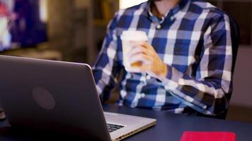 joven empresario trabajando durante horas en su hogar oficina y tomando un sorbo de café. video