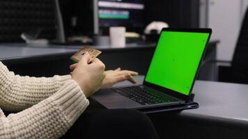 Unrecognizable person using mockup laptop working remotely at home, online shopping. Manager hands scrolling touchpad surfing in internet looking information online. Chroma key computer pad video