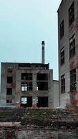 Industrial zone premises being ruined with time. Old buildings with broken windows ready to be demolished. Vertical video