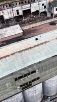 antiguo naufragios de químico planta localidad. roto paredes con enorme agujeros y escombros en el suelo. aéreo vista. vertical vídeo video