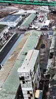 Desolate industrial area with old plant constructions. Large plant territory devastated by time. Aerial view. Vertical video