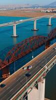 zonnig dag beeldmateriaal over- de bruggen Verbinden martinez naar Benicia, Californië, Verenigde Staten van Amerika. meerdere auto's in beweging door de bruggen. bergachtig landschap Bij achtergrond. verticaal video