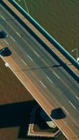 Cars on the bridge with one-direction road. Automobile bridge with pedestrian zone on the right. Top view. Vertical video