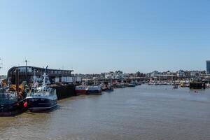 Tranquil harbor scene with moored boats and clear blue sky, reflecting a serene waterfront lifestyle in Bridlington, England. photo