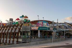 vistoso frente a la playa arcada y diversión parque con claro azul cielo en el antecedentes en los cristianos, tenerife foto