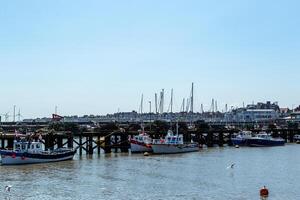 Scenic view of a harbor with boats and a pier against a clear blue sky in Bridlington, England. photo