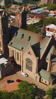 Magnificent building of Madeleine Cathedral among the urban architecture. Beautiful historic church of Salt Lake City from aerial perspective. Vertical video