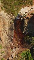 Dried waterfall in Yosemite National Park, California, USA. Steep cliffs with some vegetation on. View from top. Vertical video