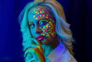 retrato de un mujer con pintado rostro, mujer con uv maquillaje en estudio, retrato de un mujer en carnaval mascarilla, el mujer es decorado en un ultravioleta polvo foto