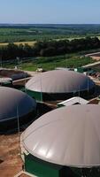 modern agrarisch complex in de landerijen. biogas fabriek voor de productie van groen energie. futuristische constructies tegen de mooi natuur landschap. verticaal video