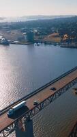 Beautiful sight of Martinez shore at the bay of California. Bridges with cars and trucks moving by. Sunny day aerial footage. Vertical video