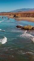 fascinante imagen de hermosa olas salpicaduras por el costa. soleado ver de morro bahía a central costa de California, EE.UU. vertical vídeo video