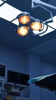 Looking at the ceiling of modern operational room with lights on. Closer look at the yellow light rotating lamps for surgeries. Low angle view. Vertical video