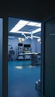 Entering the light and spacious surgery room from a dark hall. Approaching operational table with lamps switched on over it. Advanced equipment at the wall. Vertical video