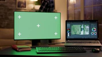 ordinateur moniteur avec vert écran dans une Accueil Bureau et vidéaste parlant sur téléphone dans le Contexte. video