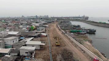 antenne beeldmateriaal van boten aangemeerd Bij de pier in een sloppenwijk en dicht bevolkt Oppervlakte in cirkelen, tanjung prik, noorden Jakarta - perahu kayu bersandar di dermaga wilayah kumuh padat penduduk 4k dar video