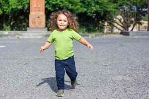 happy little boy playing in the park, long hair boy in the park photo