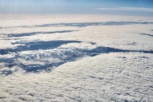 vista aérea del paisaje nublado sobre las nubes hasta ríos, carreteras, ciudades y campos cubiertos de nieve, aire invernal foto