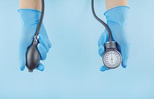 Doctor holds in his hands a medical device for measuring blood pressure on a blue background .Medical background. The medicine. Copy space. photo