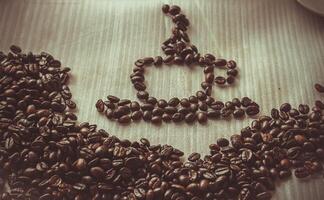 Coffee beans on wooden table with filter effect retro vintage style photo