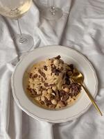 Chocolate ice cream with hazelnuts and a glass of white wine photo