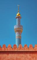 AI generated The elaborate motifs on a minaret tower capture attention against the serene blue sky photo