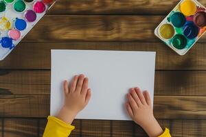 AI generated child's hands on a sheet of white paper with paints and brushes, top view photo