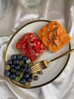 Toast with strawberry, blueberry and tangerine on a plate photo