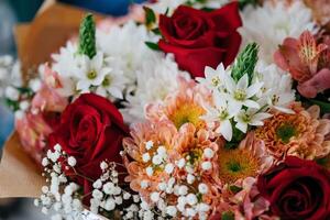 hermosa ramo de flores de diferente flores en un florero en el mesa foto