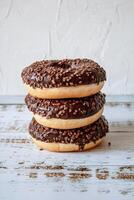 Chocolate donuts on white wooden background, selective focus, copy space photo