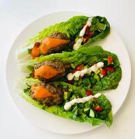 Lettuce salad with meatballs and mayonnaise on white plate photo