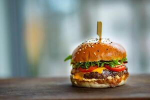 Closeup of hamburger on wooden table, shallow depth of field photo
