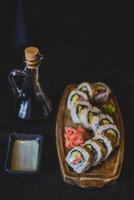 Sushi rolls on a wooden plate with soy sauce and wasabi photo