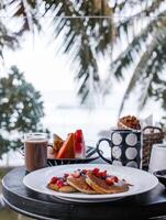 desayuno en el playa. gofres con Fresco bayas y café. foto