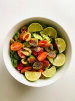 salad with cucumber, tomato, pepper and lime on white background photo