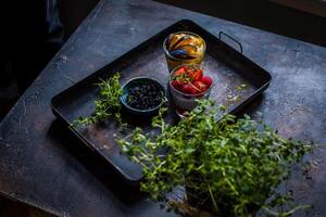 Fresco frutas y bayas en rústico de madera mesa. oscuro antecedentes. foto