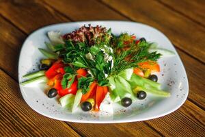 Greek salad with fresh vegetables and feta cheese on a wooden table photo