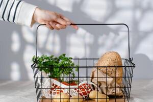 recortado ver de mujer señalando con dedo a compras cesta con comida foto